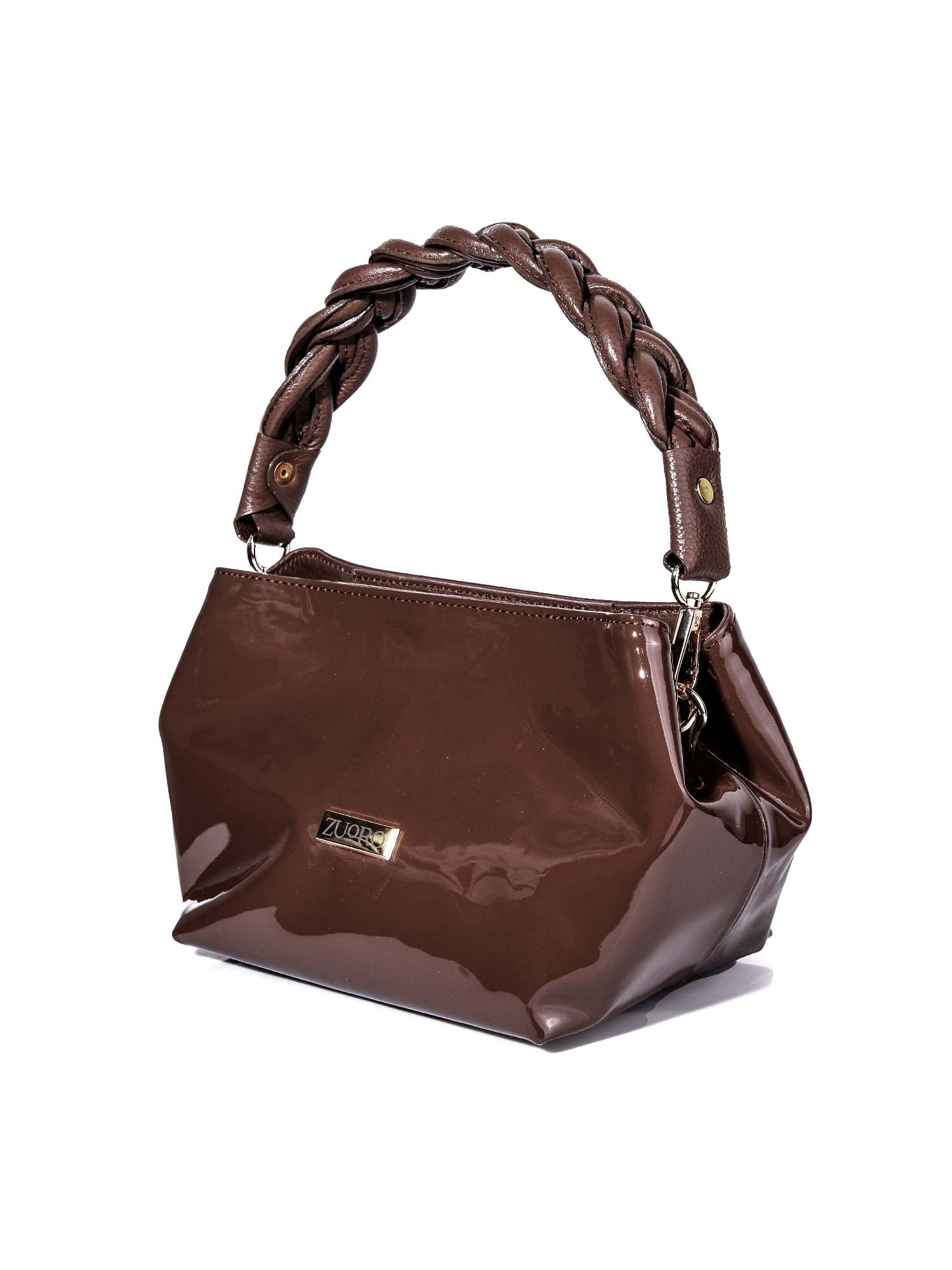 Bolso de mano hexagonal modelo Adele en color chocolate, destacando el asa rígida trenzada artesanalmente y detalles en herrajes dorados