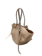 Bolso flexible modelo Zamia en color luna (metalizado champaña), con diseño de laterales ajustables y cargaderas dobles estilizadas