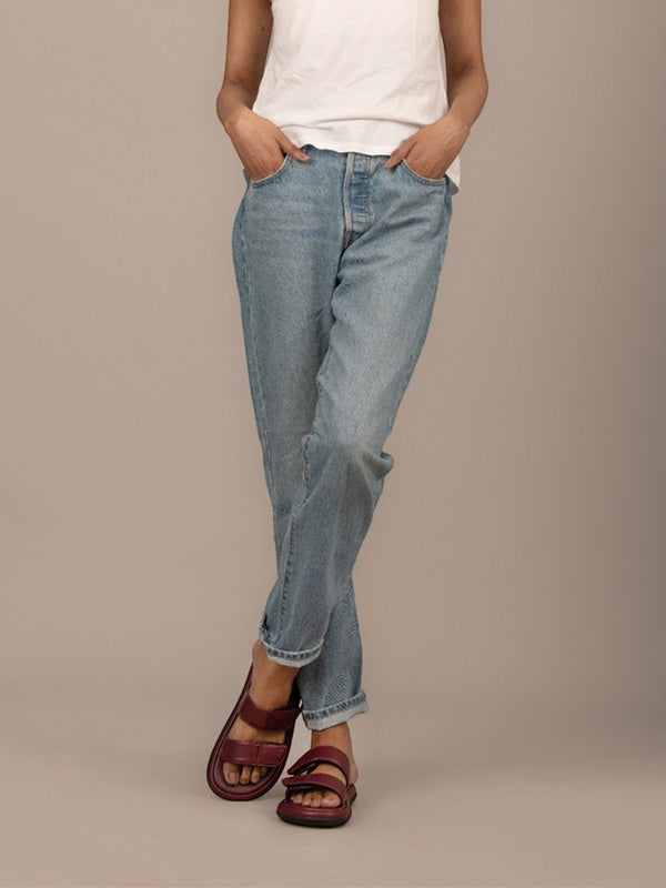 Primer plano del material vinotinto y costuras de la sandalia Aria, resaltando el cierre de velcro y el acabado de lujo artesanal