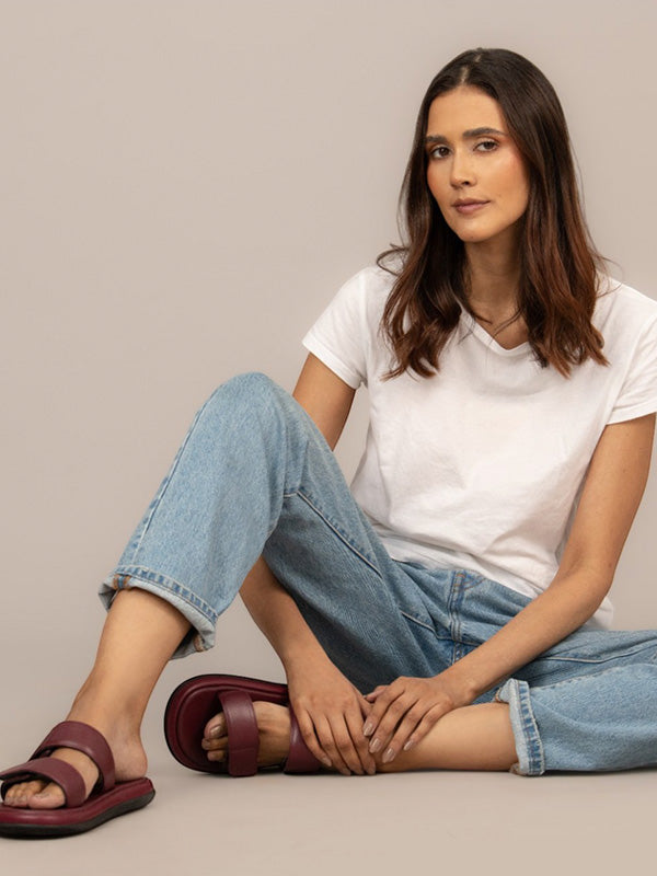 Modelo usando sandalias tipo chancla elegantes Aria en vinotinto, calzado sofisticado de uso diario con diseño minimalista