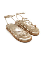 Sandalia plana modelo Begonia de Zuoro Shoes en color dorado, con diseño de tiras finas minimalistas y ajuste de hebilla al tobillo