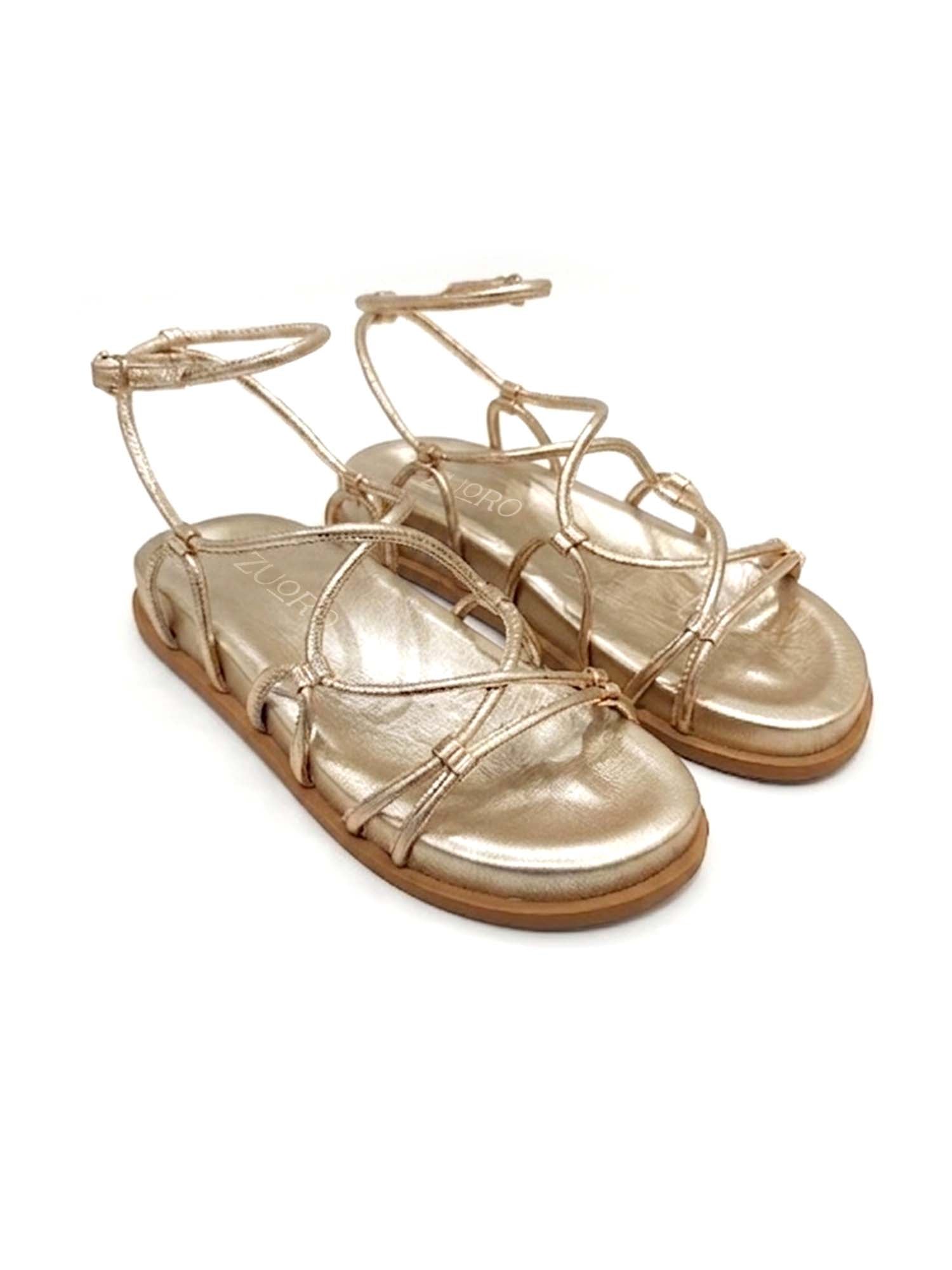 Sandalia plana modelo Begonia de Zuoro Shoes en color dorado, con diseño de tiras finas minimalistas y ajuste de hebilla al tobillo