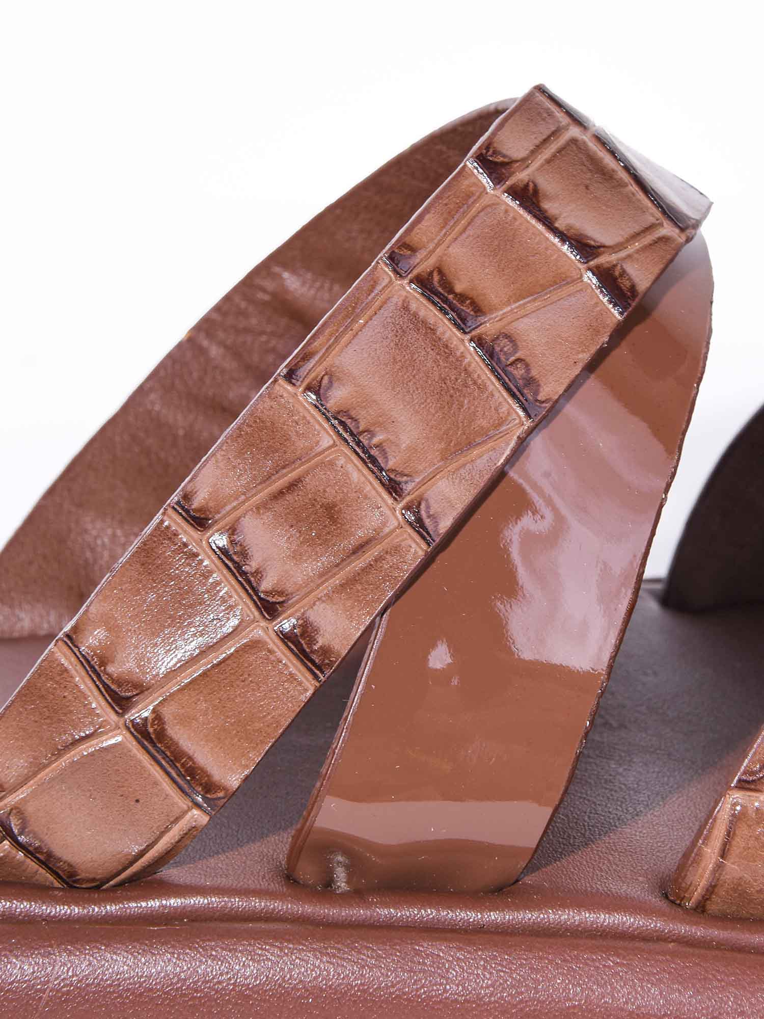 Detalle en primer plano de la capellada Brissa marrón: contraste entre el grabado de cocodrilo y la tira brillante de alta calidad