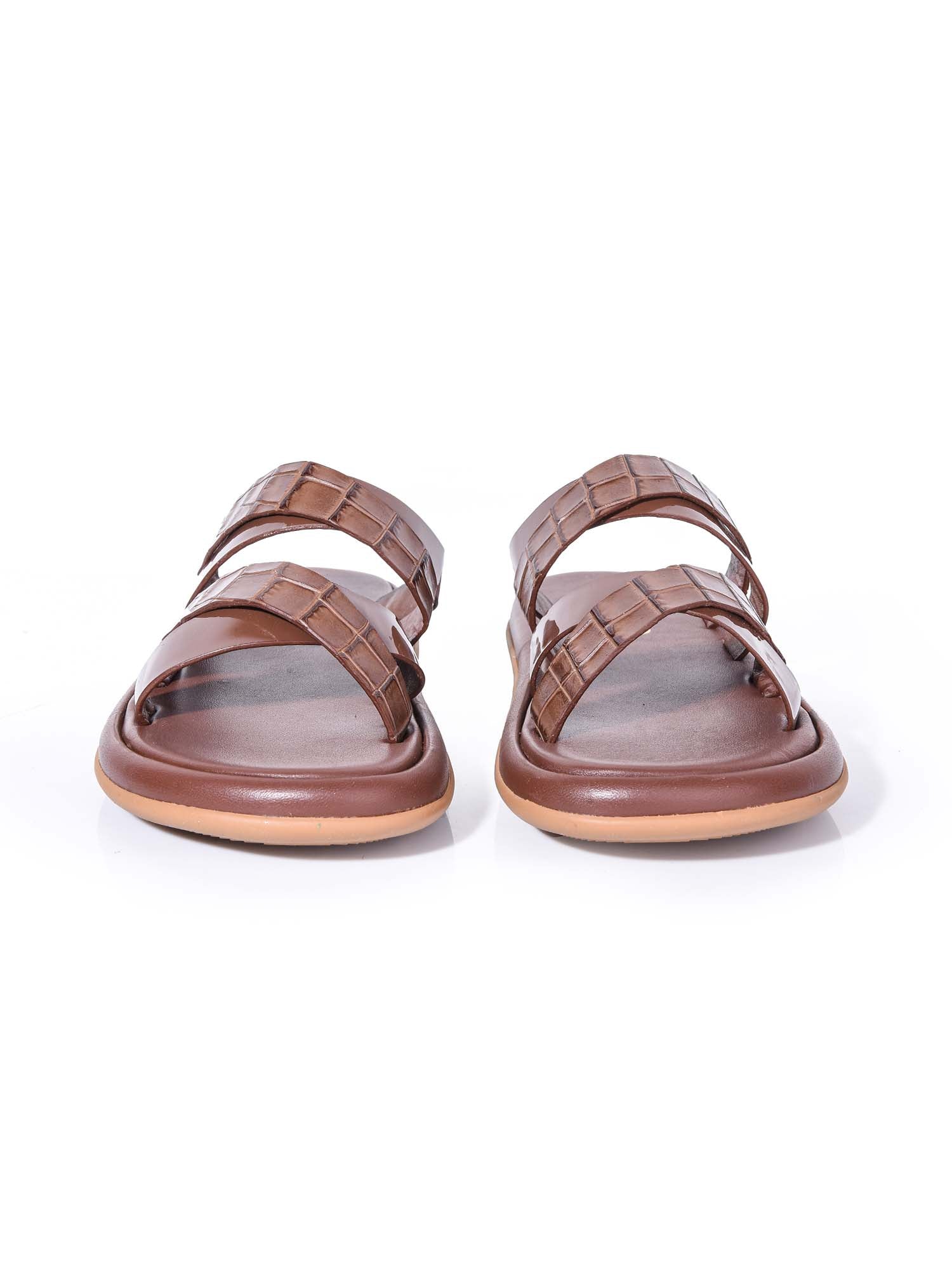 Vista frontal de la sandalia Brissa marrón resaltando el cruce artesanal de las tiras texturizadas y la horma ancha de la suela