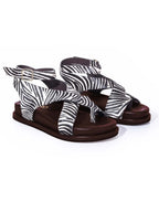 Sandalia plana modelo Corinna de Zuoro Shoes en animal print de cebra, con diseño de tiras entrelazadas que envuelven el pie con elegancia