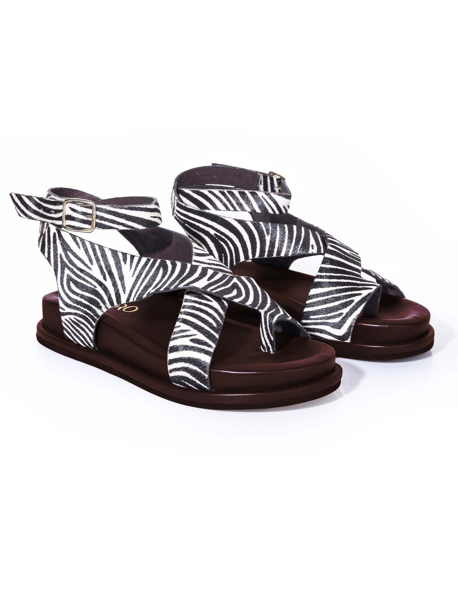 Sandalia plana modelo Corinna de Zuoro Shoes en animal print de cebra, con diseño de tiras entrelazadas que envuelven el pie con elegancia