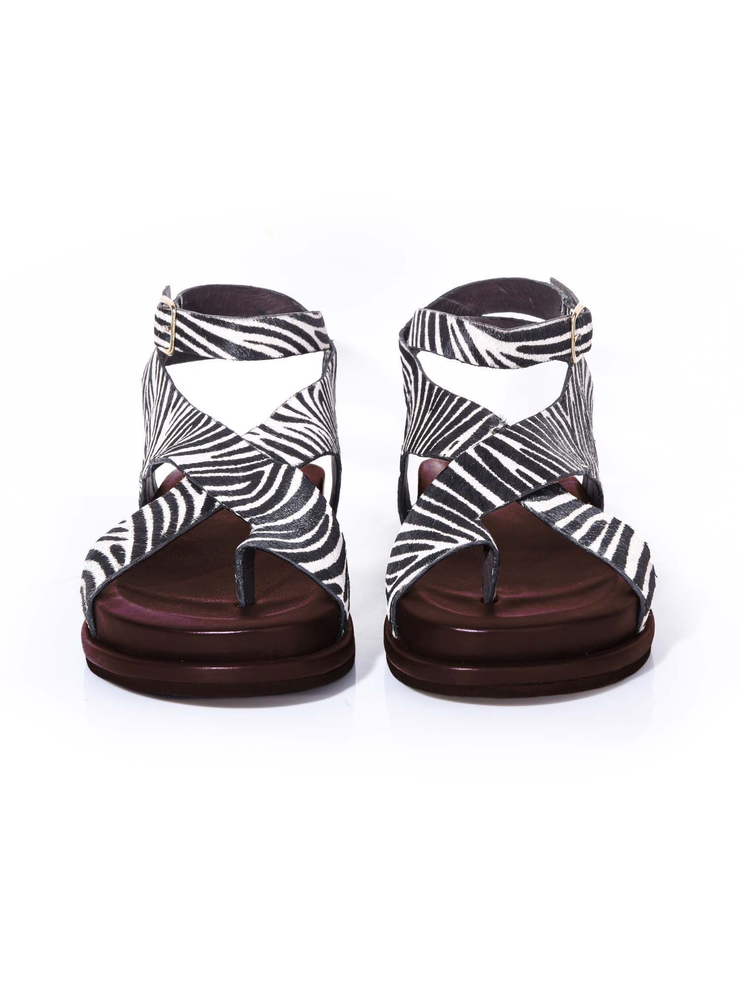 Vista frontal de la sandalia Corinna resaltando el patrón gráfico de cebra y la disposición cruzada de las tiras sobre el empeine