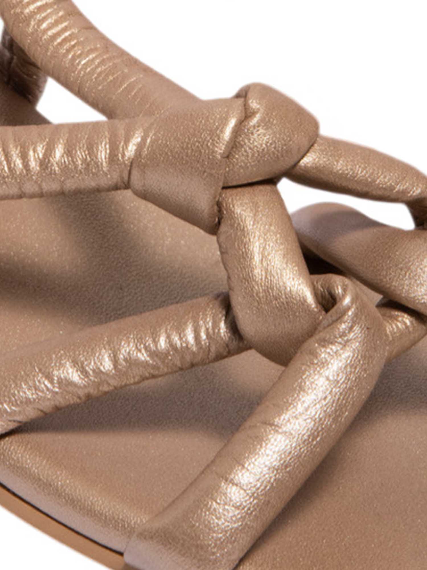 Acercamiento al nudo artesanal de la sandalia Duna dorado, resaltando su acabado manual y el color dorado elegante