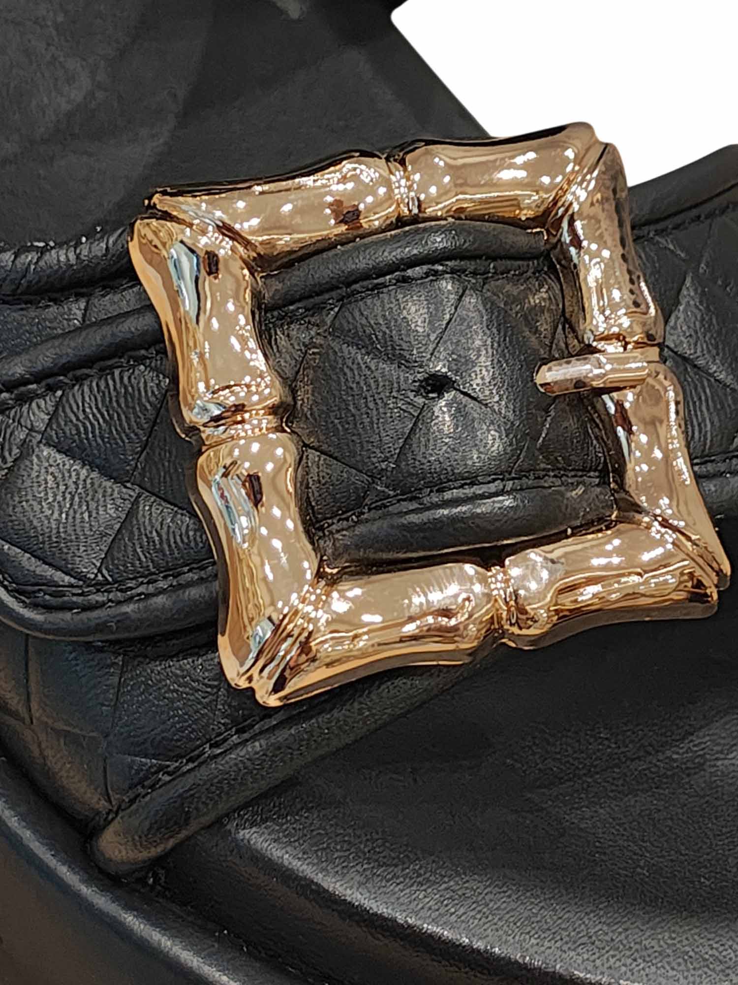 Primer plano del cuero negro texturizado y el acabado de las hebillas frontales en la sandalia Gardenia de Zuoro Shoes