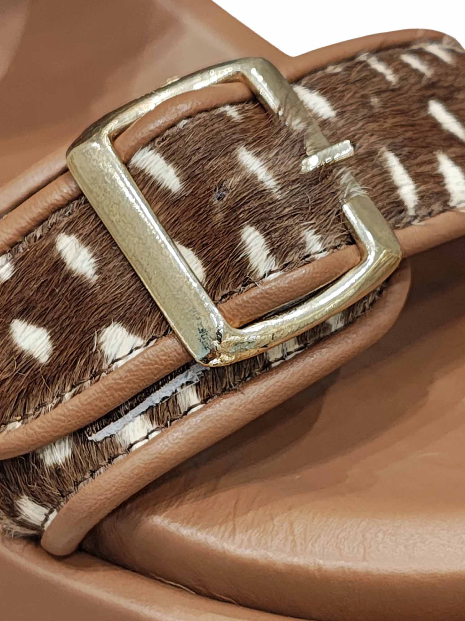 Primer plano de la textura print del modelo India y el acabado de las hebillas metálicas en las bandas frontales