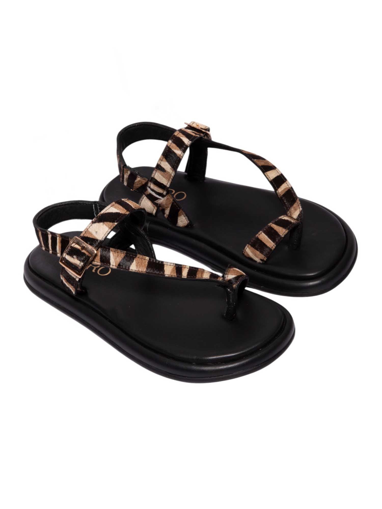 Sandalia plana modelo Kala de Zuoro Shoes en animal print, con diseño de tiras cruzadas al dedo y ajuste de hebilla al tobillo