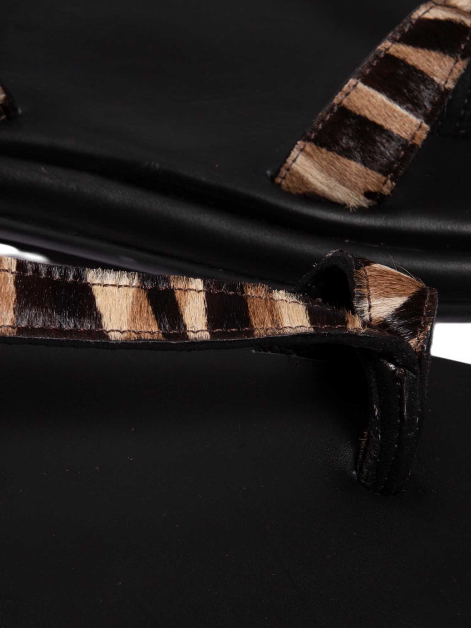 Primer plano del modelo Kala destacando la calidad del cuero texturizado animal print y el acabado de la hebilla de ajuste