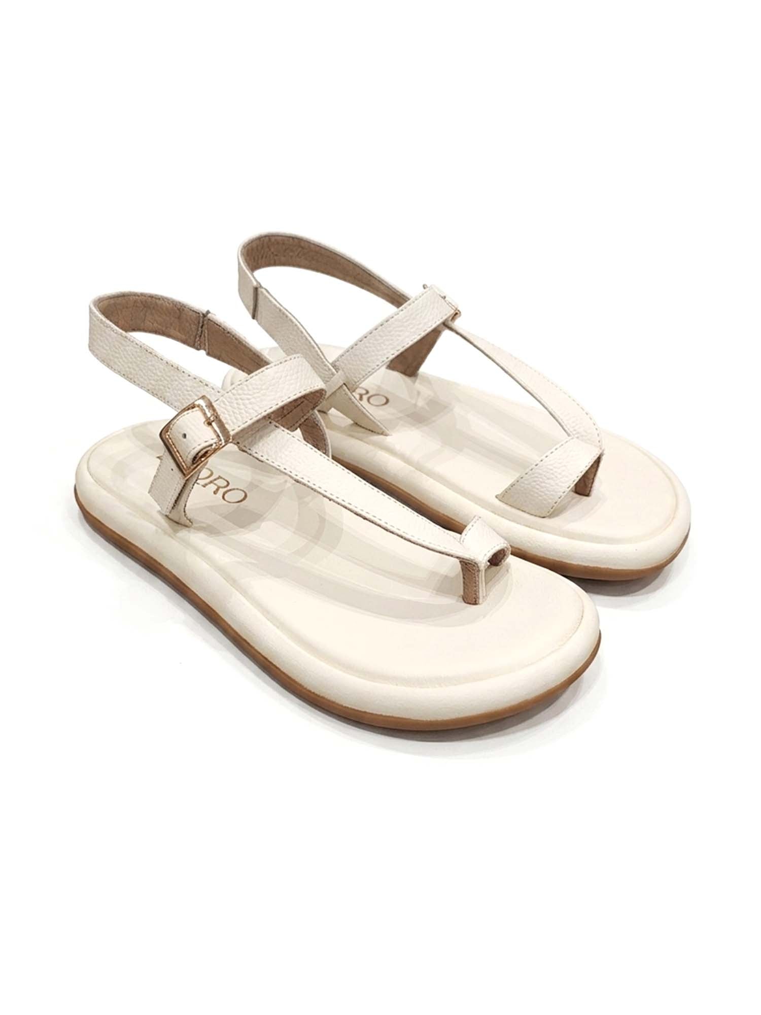 Sandalia plana modelo Kala de Zuoro Shoes en color talco, con diseño de tiras cruzadas al dedo y ajuste de hebilla al tobillo