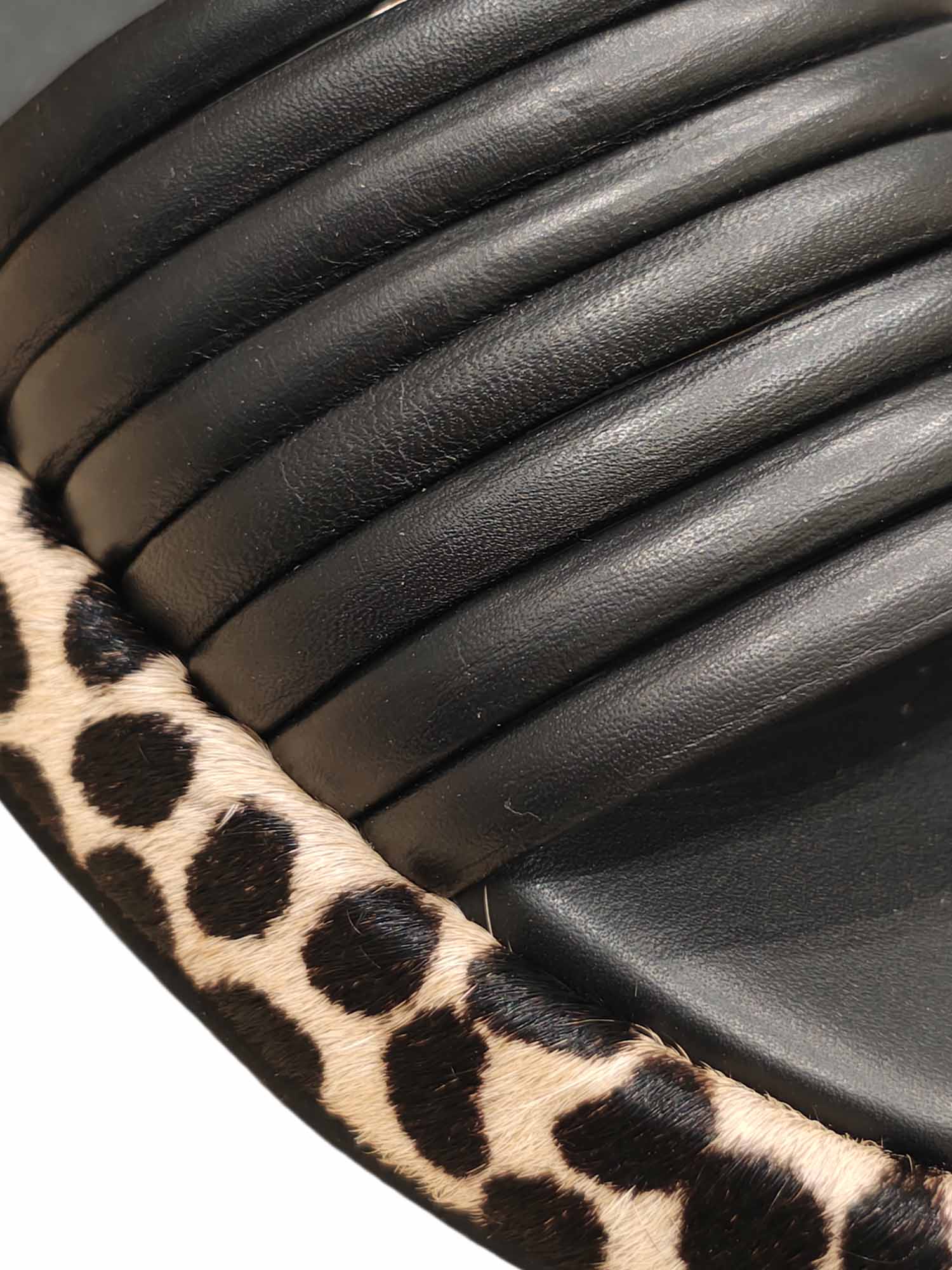 Primer plano del acolchado en las tiras negras y el detalle del recubrimiento en animal print de la plataforma Loto