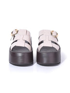 Vista frontal de la sandalia Alta beige resaltando la cobertura de las tiras sobre el empeine y la robustez de la suela negra