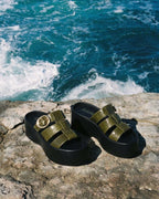 Imagen de las sandalias de plataforma Alta de Zuoro Shoes sobre una roca al borde del mar, mostrando un look veraniego y fresco