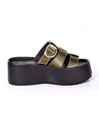 Perfil del modelo Alta de Zuoro Shoes, mostrando la imponente plataforma negra y la estructura envolvente de la capellada verde