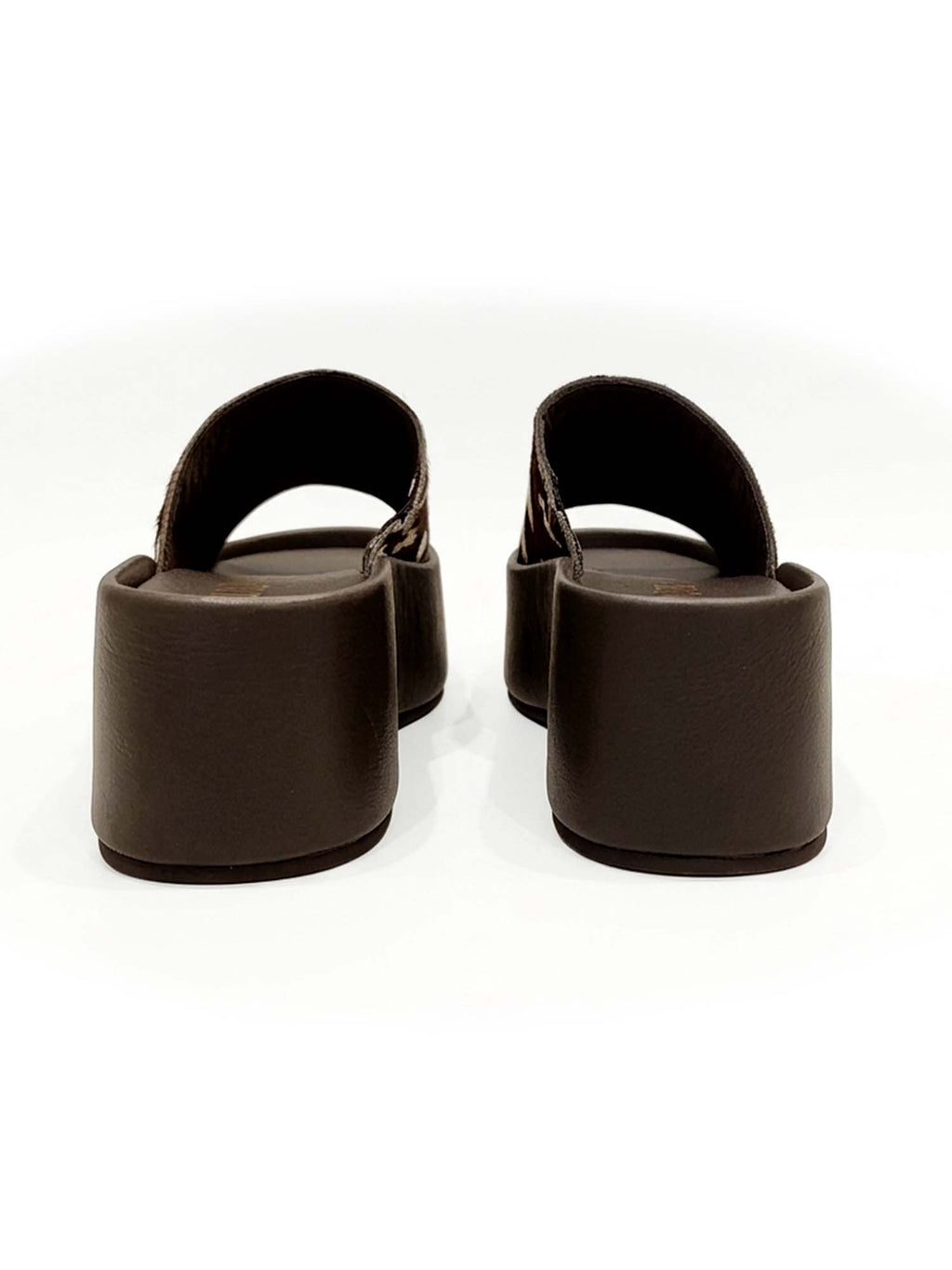 Vista posterior del modelo Nua, mostrando el talón abierto para un calce rápido y la robustez de la plataforma café