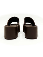 Vista posterior del modelo Nua, mostrando el talón abierto para un calce rápido y la robustez de la plataforma café