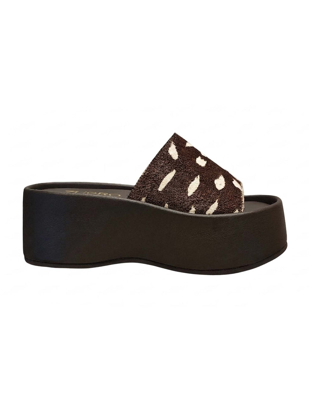 Perfil de la plataforma Nua resaltando la elevación uniforme de la suela y la estructura continua de la capellada en animal print