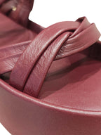 Primer plano de los nudos artesanales y el cruce de múltiples tiras en la sandalia flatform Seda, resaltando la riqueza del tono vinotinto de Zuoro Shoes