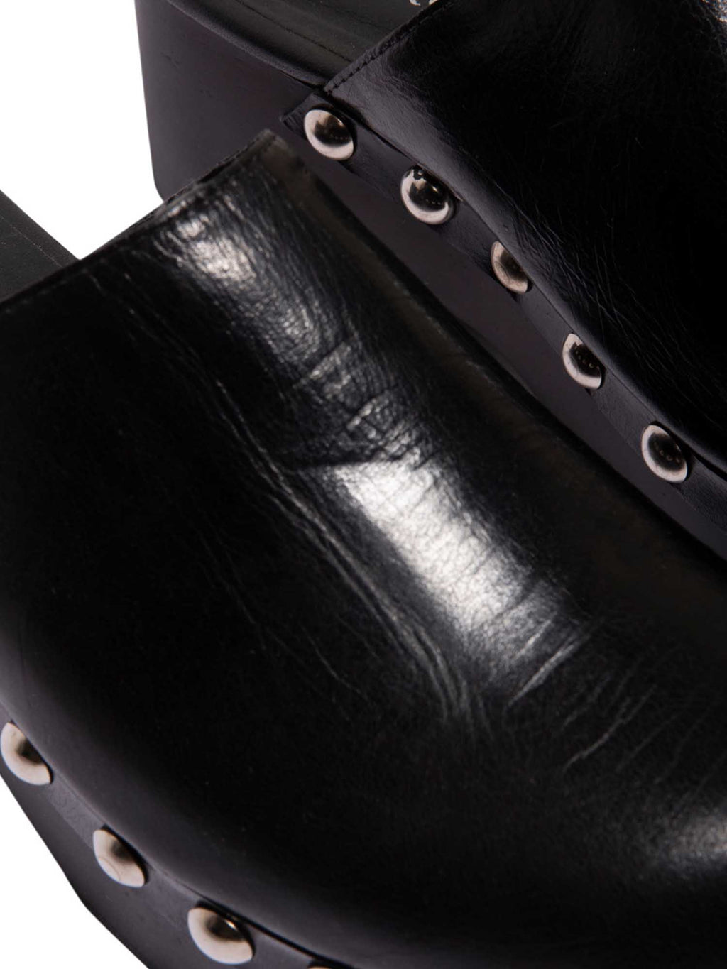 Primer plano de la capellada de la sandalia Tabata, resaltando la calidad del cuero negro y el acabado de lujo de los taches