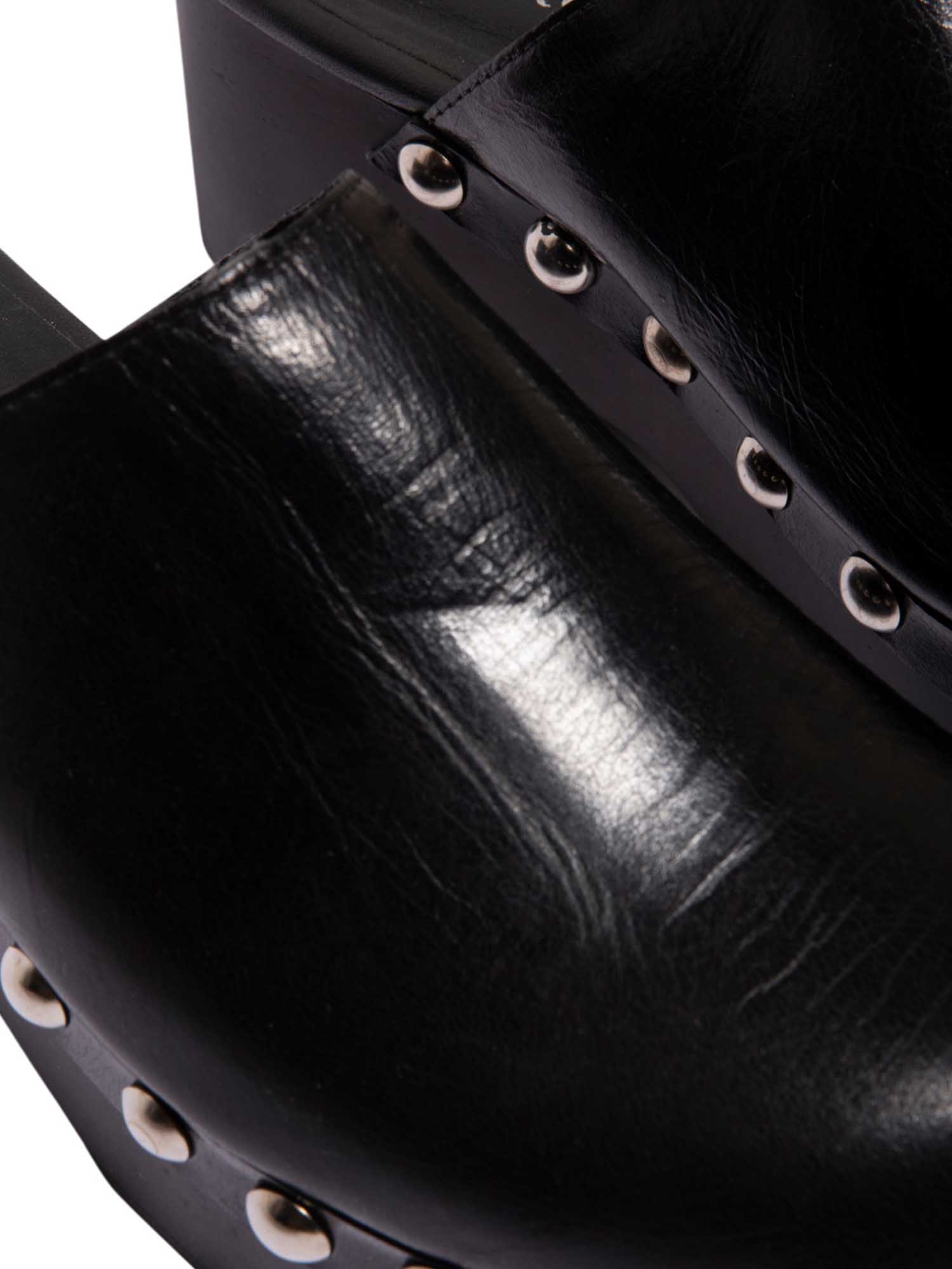 Primer plano de la capellada de la sandalia Tabata, resaltando la calidad del cuero negro y el acabado de lujo de los taches