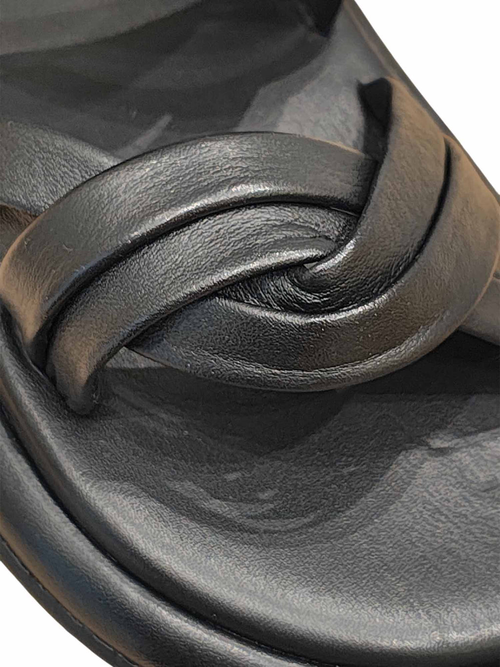 Primer plano de las tiras negras anudadas de la sandalia Seda, resaltando la técnica artesanal y el brillo sutil del material