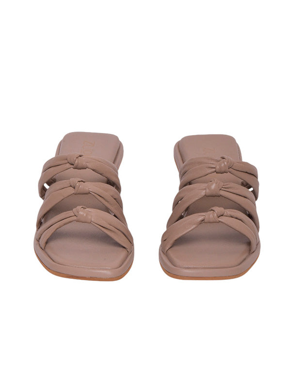 Vista frontal de los tacones Faela resaltando el intrincado tejido trenzado de la banda frontal y su silueta de punta cuadrada elegante