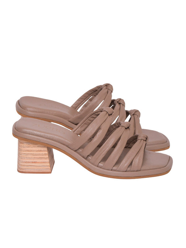 Perfil del modelo Faela de Zuoro Shoes, mostrando el contraste entre el tejido beige y el tacón robusto con textura de madera natural