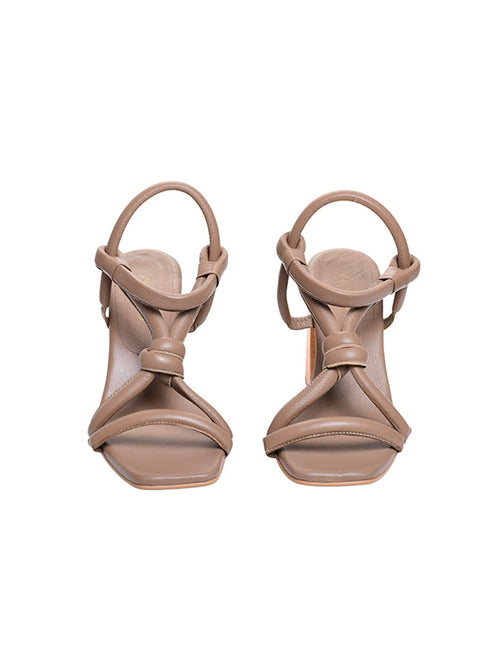 Vista frontal del tacón Prata beige resaltando el volumen de los nudos frontales y la punta cuadrada elegante